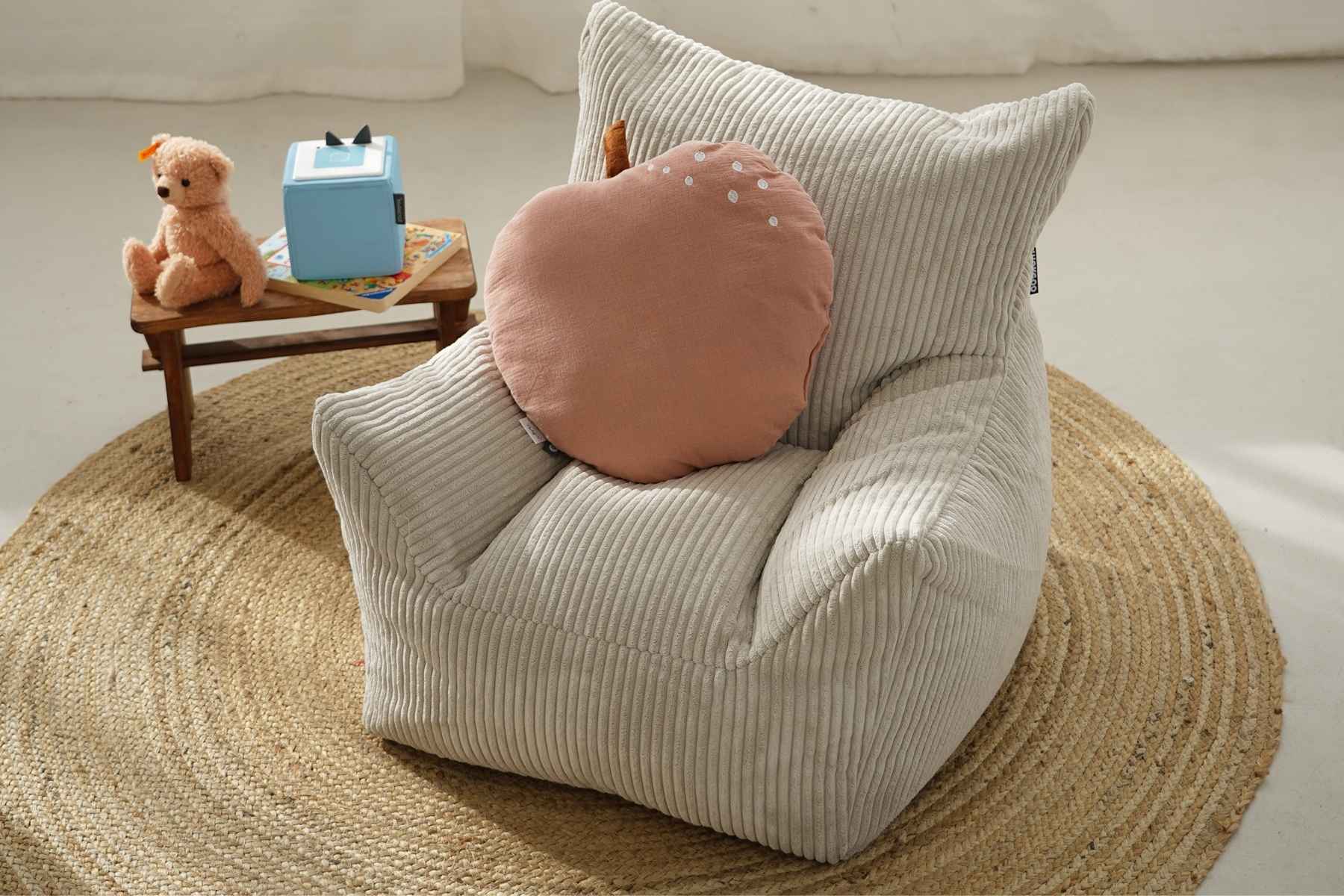 Pouf pour enfants en velours côtelé beige dans une chambre d'enfant. petit coussin sur le pouf