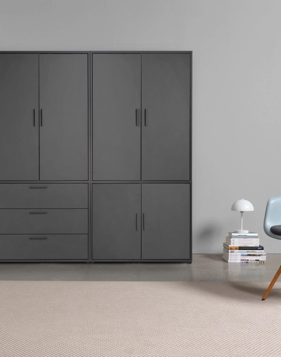 armoire noire contre un mur, quatre portes en haut, trois compartiments et deux portes en bas